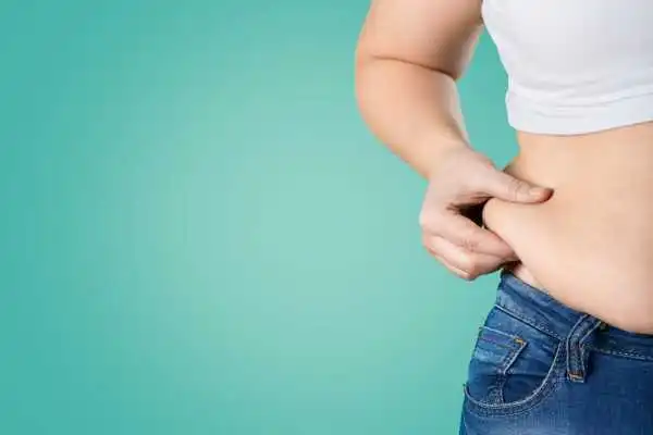 Image of woman pinching her love handles to show weight gain Ilford